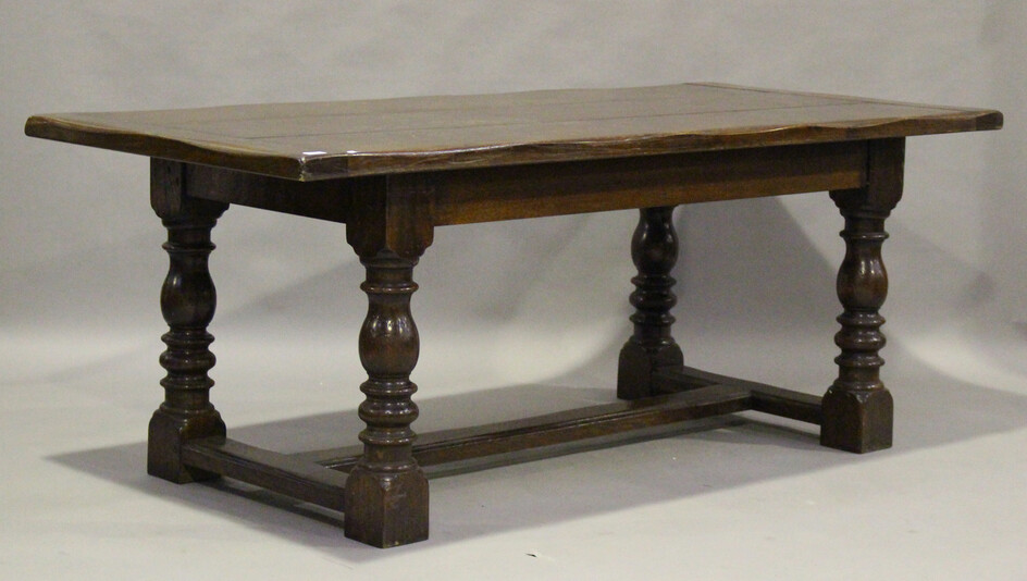 A 20th century Jacobean Revival oak refectory style dining table, raised on turned and block legs un