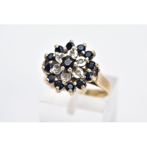 A 9CT GOLD SAPPHIRE AND DIAMOND CLUSTER RING, the large slig...