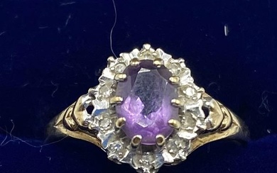 A 9ct gold amethyst and diamond ring. Central oval...