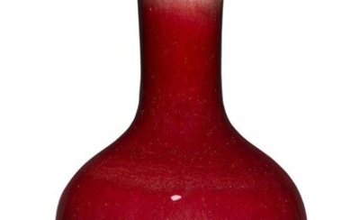 A Chinese porcelain monochrome langyao glazed vase, tianqiuping, 19th century, covered in a rich deep red glaze thinning to milky-white around the rim, 37cm high