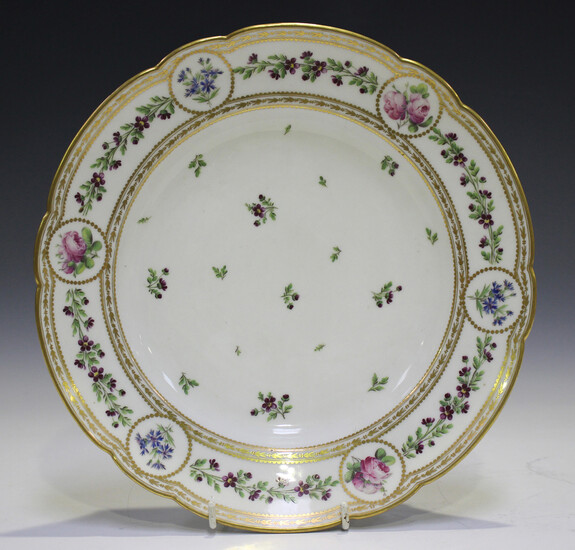 A French porcelain circular dish, late 19th century, painted to the centre with scattered floral spr