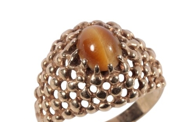 A GOLD TIGERS EYE DRESS RING the oval-cut tigers eye, raised...