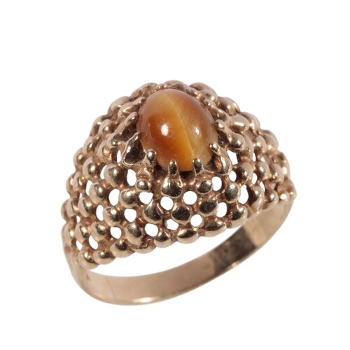 A GOLD TIGERS EYE DRESS RING the oval-cut tigers eye, raised...