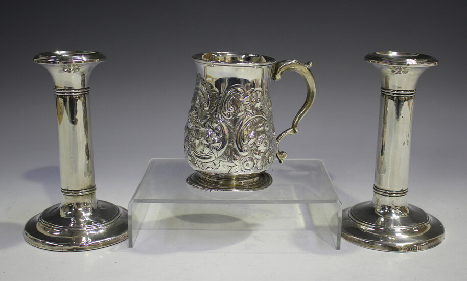 A George III silver tankard of baluster form with foliate capped scroll handle, the body later chase