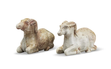 A PAIR OF MOTTLED GREYISH-WHITE JADE FIGURES OF RECUMBENT RAMS CHINA, HAN DYNASTY OR LATER
