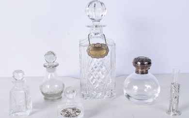 A collection of perfume bottles one with a silver top together with a Decanter with a silver label 1