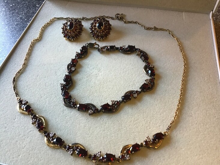 A garnet jewellwey set comprising a necklace, a bracelet and a pair of ear clips each set with numerous garnets, mounted in gold plated sterling silver.