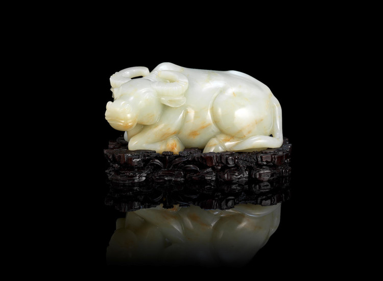 A large pale green jade carving of a recumbent buffalo