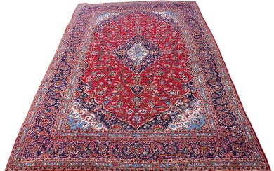 A large red ground Persian Kashan carpet, in red, blue, gree...