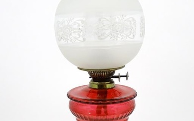 A late 19th / early 20thC oil lamp with brass column and cranberry glass reservoir with etched glass