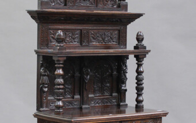 A late 19th/early 20th century Continental carved oak side cabinet with a panelled shelf back above