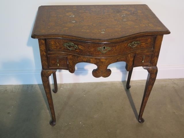 A marquetry inlaid bow fronted side table with a frieze draw...