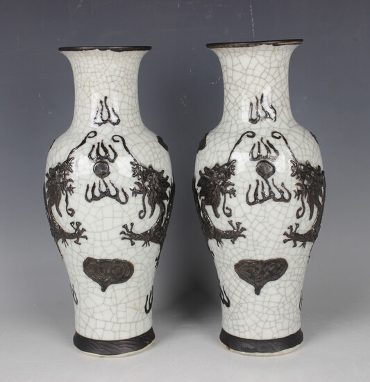 A pair of Chinese crackle glazed and relief moulded porcelain vases with iron oxide washed decoratio