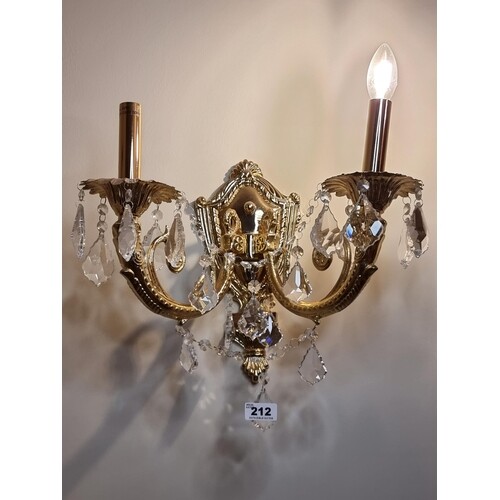 A pair of brass two-branch wall sconces with facet cut drop ...