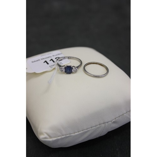 A platinum three stone dress ring, set central sapphire, and...