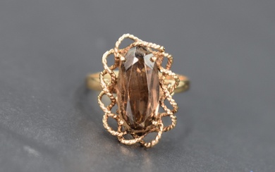 A smoky quartz dress ring, the oval cut smoky quartz set in a decorative twisted rope motif