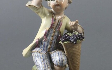 Allegory of autumn/boy with grapes Probably Meissen 18th century, porcelain, glazed and polychrome painted, additionally decorated with a sparse gold staffage, boy sitting on a natural base decorated with rocailles, a supporting trunk, beside him a...