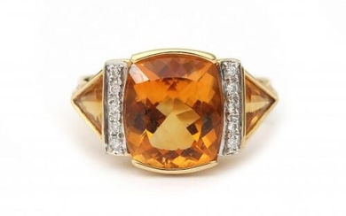 An 18 karat gold citrine and diamond ring. Featuring a cushion cut citrine of ca. 5.5 ct. in the center, flanked by ten brilliant cut diamonds in total en two trilliant cut citrines. Gross weight: 7.5 g.