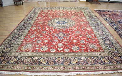 An Iranian carpet, the red ground with a gold medallion...