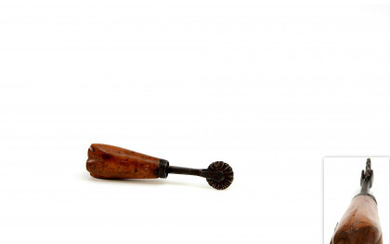 An iron pastry jigger with a wooden stamp