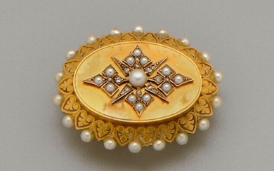 Broche porte souvenirs ancienne ovale en or jaune 18K (750/oo) à décor festonné serti de...