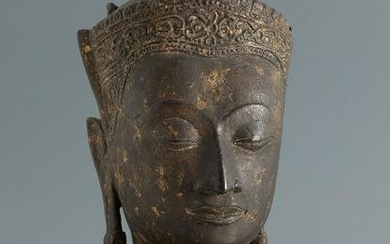 Buddha's head. Burma or Thailand, 17th century. Polychrome metal. Wooden pedestal. Lacks polychromy.