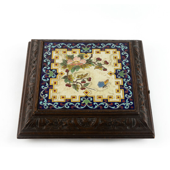 Chauffe-plat in de vorm van een vierkante tegel (21 x 21 cm) in meerkleurig geglazuurd aardewerk gevat in een houder in