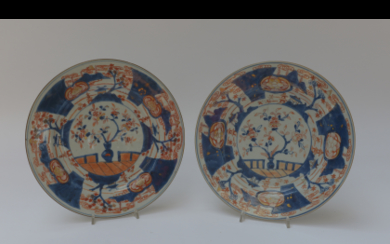Coppia di piatti in porcellana Imari decorati con motivi floreali e paesaggi (difetti) Giappone, sec. XVIII (d. 30 cm)