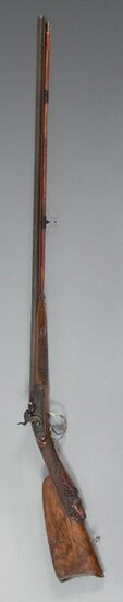 Flintlock shotgun transformed to percussion, double barrel in tobacco-coloured damascus, length 89.5 cm, calibre 16.5 mm; breech tail engraved with foliage and a hammer in a cartridge; flat-bodied locks, engraved and signed : "Berleur" and "Michel"...