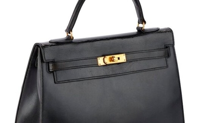 Kelly bag "32" in rigid black box, gold metal fasteners and clasp, handle, black leather lining with three pockets. Without key, without padlock or shoulder strap. Nice general look. A few cracks, a few scratches of use with an important under...