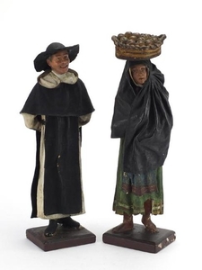 Pair of carved wood and plaster figures of peasants, the lar...
