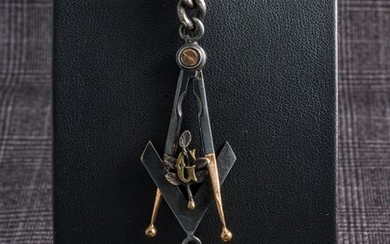 Pendentif Memento Mori en os sculpté soutenu par une chaîne en métal, de l’équerre, du compas et de la lettre G Longueur : 10 cm