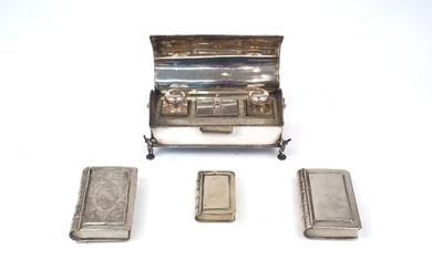 Three boxes modelled as books, white metal, apparently unmarked, designed with hinged lids and realistically banded spines, one with decorative engraving to cover, together with a Victorian silver plated desk stand, the domed lid opening to reveal...