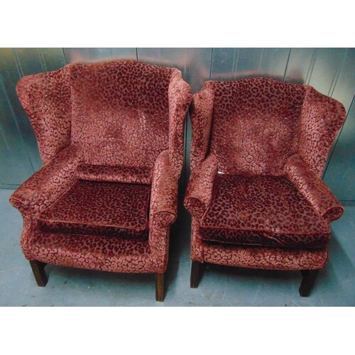 Two upholstered wing back armchairs on four tapering rectang...