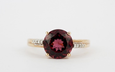 A 14ct rose gold ring set with a round cut garnet and diamond set shoulders, (O).