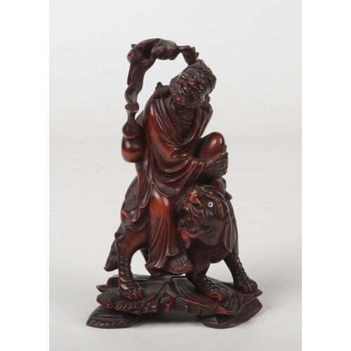A 19th century Chinese carved wood figure of a man mounted u...