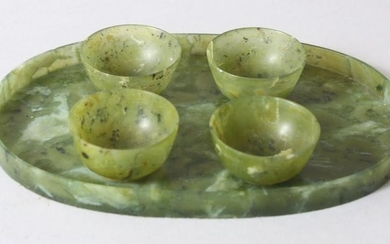 A CHINESE MOTTLED GREEN JADE OVAL TRAY AND FOUR TEA