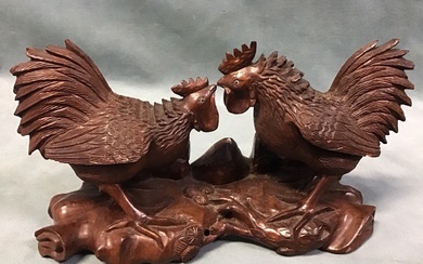 A Chinese carved hardwood figure of two duelling cockerels with...
