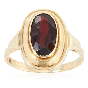 A GARNET DRESS RING in yellow gold, set with an oval