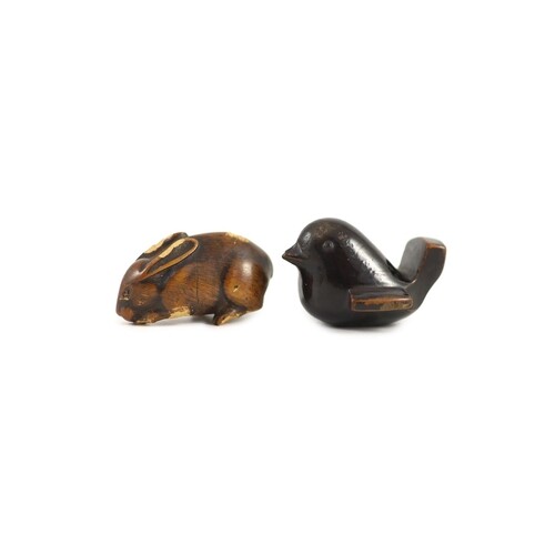 A Japanese lacquered wood netsuke of a bird and a wooden net...