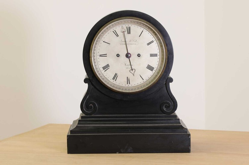 A black marble drumhead mantel clock