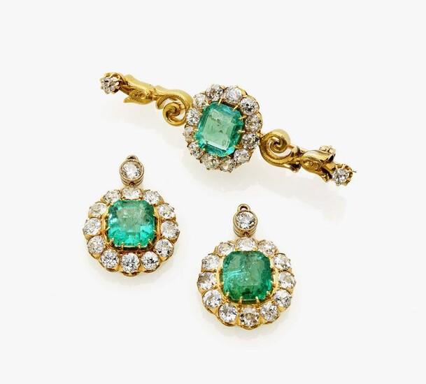 A brooch and a pair of earrings with emeralds and