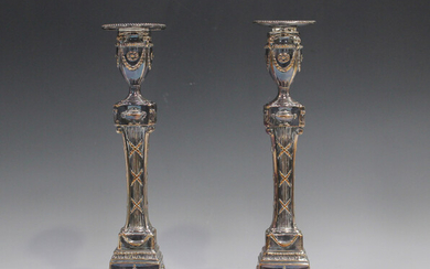 A pair of 19th century Sheffield plate candlesticks, each with a detachable beaded nozzle above an o