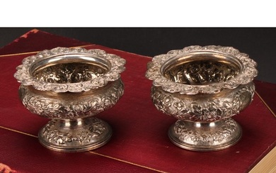 A pair of George IV silver ovoid pedestal salts, chased with...