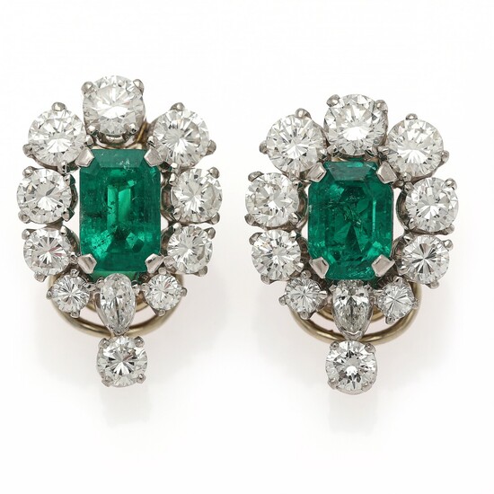 A pair of ear clips each set with an emerald encircled by numerous diamonds, mounted in platinum and 18k gold. (2)