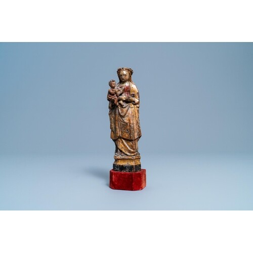 A polychromed and gilded wooden figure of a Madonna with chi...