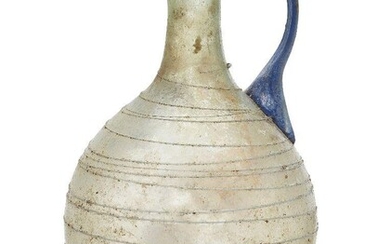 A small Roman light green glass jug, 1st century A.D.,...