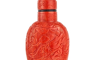 AN ANTIQUE CHINESE CORAL SNUFF BOTTLE comprising coral carved to depict dragons, the lid lifting ...