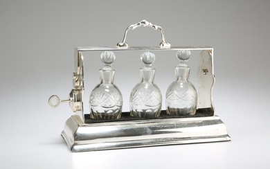 AN EDWARDIAN SILVER-PLATED THREE-BOTTLE TANTALUS, the