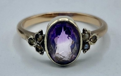 An unmarked yellow metal amethyst and pearl ring. 2.35g....